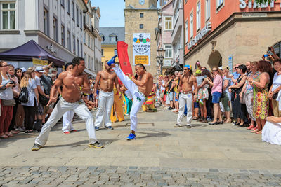 People on street amidst buildings in city