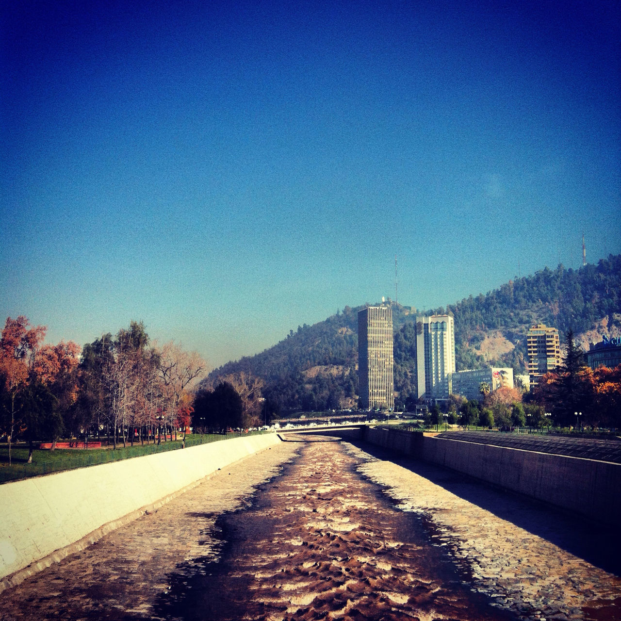 clear sky, blue, the way forward, building exterior, architecture, built structure, copy space, diminishing perspective, road, city, tree, street, vanishing point, long, transportation, empty, sky, walkway, outdoors, sunlight