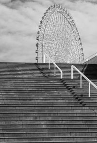 Low angle view of stairs against ferris wheel