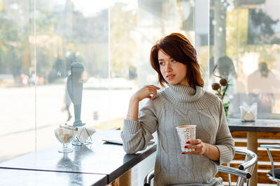 Portrait of charming young woman with friendly smile, brunette in a knitted