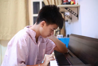 Rear view of man playing piano