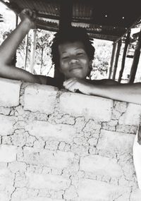 Portrait of young woman standing against wall