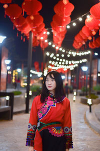 Portrait of beautiful young woman standing at night