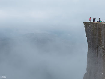 People standing on mountain against sky