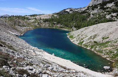 Scenic view of lake by mountains against sky