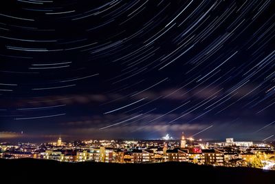 Illuminated city against sky at night