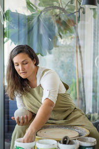 Woman making pottery on the wheel