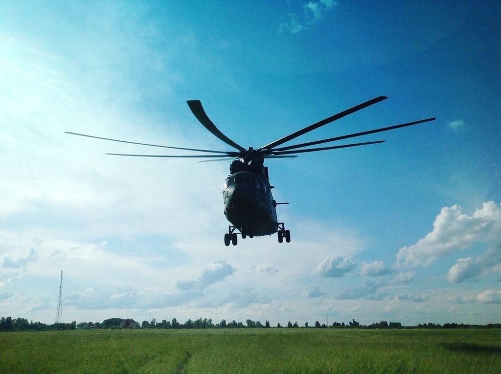 field, transportation, sky, mode of transport, wind power, landscape, air vehicle, windmill, alternative energy, wind turbine, cloud - sky, rural scene, flying, environmental conservation, fuel and power generation, airplane, mid-air, renewable energy, blue, agriculture