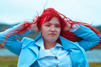 Close-up of young woman with hand behind head