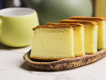 Slices of japanesse cake on green oval plate with white background