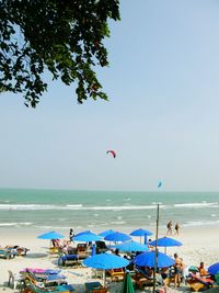 People at beach against clear sky