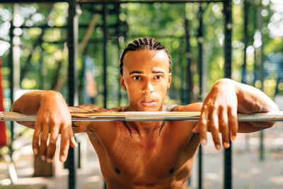 Portrait of young man standing by railing