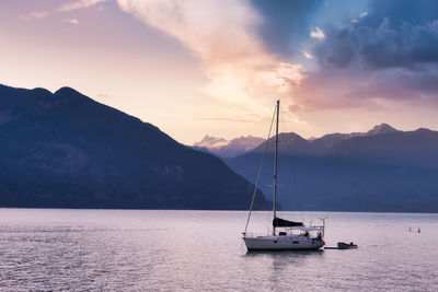 Sailboats in sea against sky during sunset