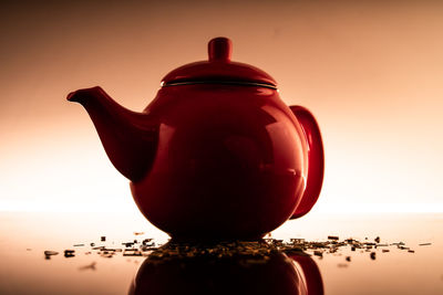 Close-up of red wine on table against sunset