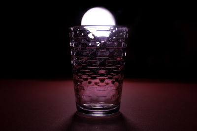 Close-up of drink in glass on table against black background