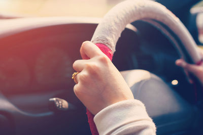 Cropped hand of woman driving car