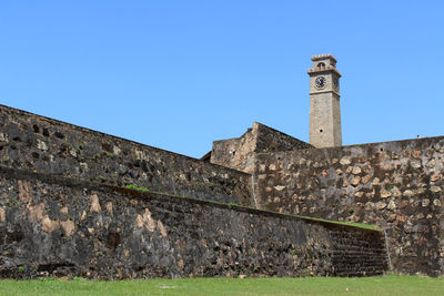 Low angle view of old building against blue sky