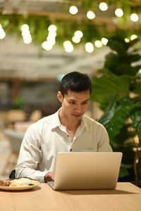 Young man using laptop at table