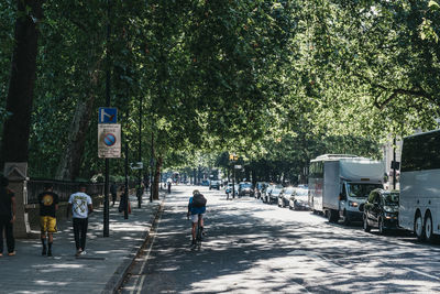 Rear view of people walking on road in city