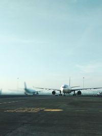 Airplane on runway against sky