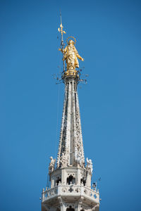 View to spires and statues on roof of duomo through ornate marble fencing. milan, italy