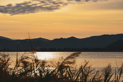 Scenic view of lake against orange sky