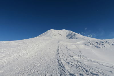 Scenic view of snowcapped mountains against clear blue sky