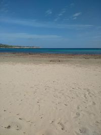 Scenic view of beach against blue sky