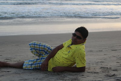 Portrait of smiling young woman sitting on beach