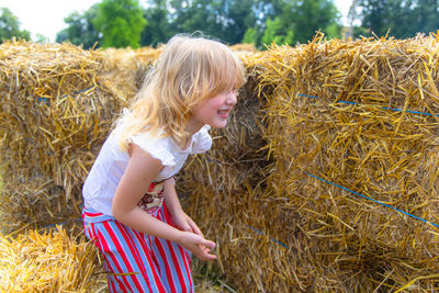 Full length of young woman sitting on hay