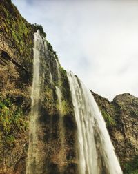 Low angle view of waterfall against sky