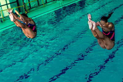 High angle view of athletes diving into swimming pool