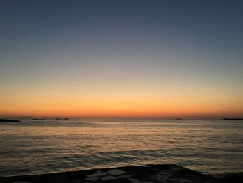 Scenic view of sea against clear sky at sunset