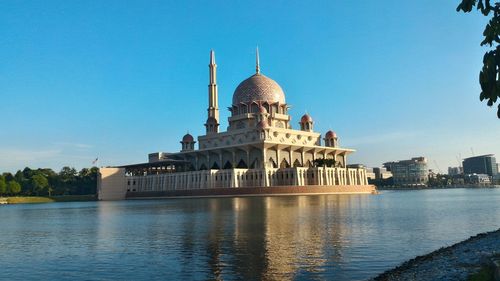Putra mosque by lake against sky