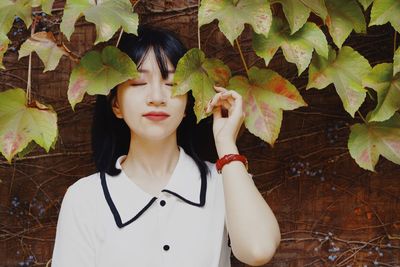 Portrait of a young woman with red leaves