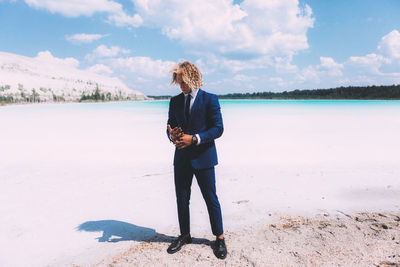 Full length of woman standing on beach against sky