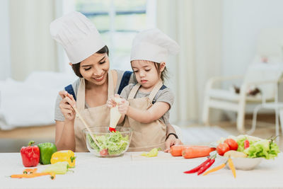 Midsection of woman having food in kitchen