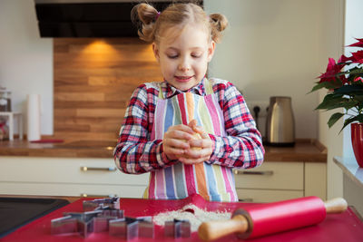 Smiling girl making cookies at home