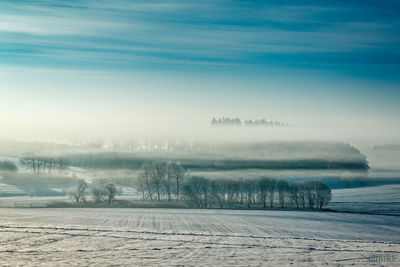 Scenic view of lake against sky during winter