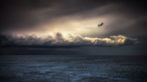 Scenic view of sea against storm clouds