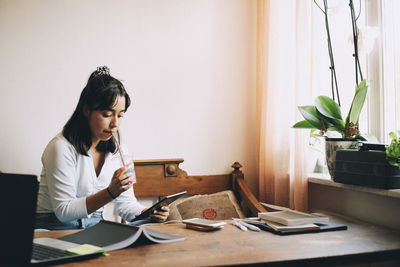 Woman sitting on table at home