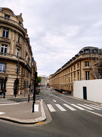 Surface level of road by buildings against sky