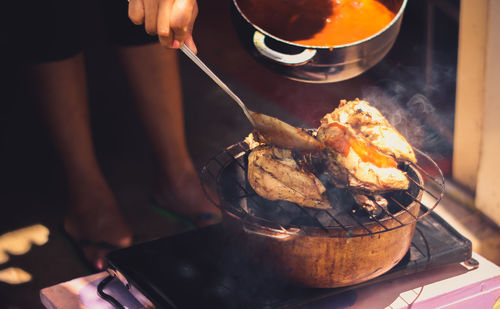 Low section of man preparing food on barbecue grill