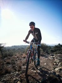 Full length of man riding bicycle on mountain against sky