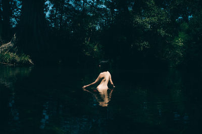 Shirtless woman swimming in lake