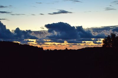 Scenic view of dramatic sky over silhouette landscape