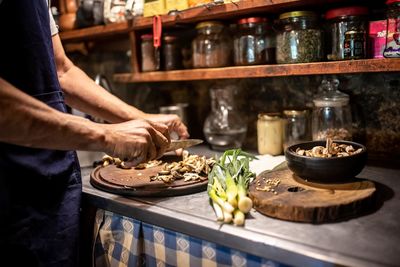 Midsection of man preparing food in kitchen