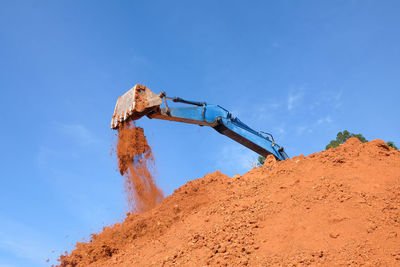 Low angle view of crane against blue sky