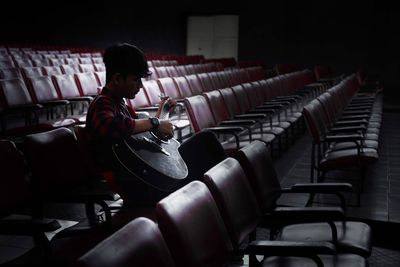 Side view of boy sitting on chair