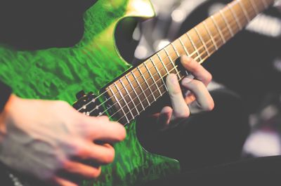 Midsection of man playing guitar